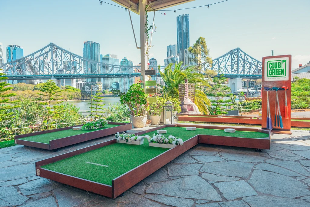 Mobile mini-golf course on a Brisbane rooftop with the cityscape behind